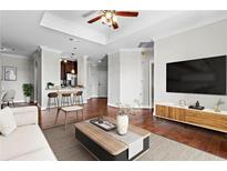 Bright and airy living room with wood floors, a coffered ceiling, and a modern entertainment center at 325 E Paces Ferry Ne Rd # 703, Atlanta, GA 30305