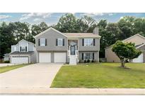 Charming two-story home with gray siding, double garage, and well-maintained front lawn at 1087 Berkley Se Dr, Smyrna, GA 30082