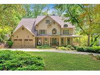 Stunning two-story home boasts a three-car garage, a manicured lawn, and a charming front porch, all surrounded by lush greenery at 3925 Sheldon Ne Dr, Atlanta, GA 30342