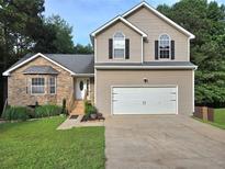 Inviting two-story home with a two-car garage, stone accents, and well-maintained lawn at 4284 Caroline Ct, Douglasville, GA 30135