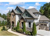 Beautiful two-story home featuring stone accents, manicured landscaping, and a welcoming two-car garage at 3111 Old Thompson Mill Rd, Buford, GA 30519
