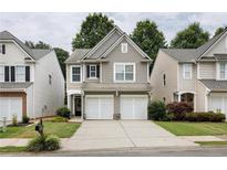 Charming two-story home with a well-maintained front yard and a two-car garage at 303 Barberry Pl, Canton, GA 30114