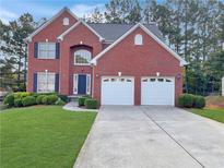 Charming red brick two-story home with a well-manicured lawn and a two-car garage at 3515 Mcclure Woods Dr, Duluth, GA 30096