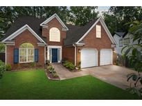 Charming two-story brick home with a well-manicured lawn and a two-car garage at 565 Saint James Ct, Lawrenceville, GA 30044