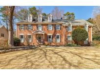 Beautiful two story brick home with dormer windows and a manicured front yard at 656 Gunby Se Rd, Marietta, GA 30067