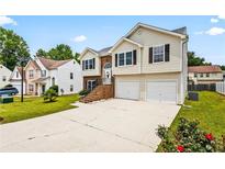 Two-story home with a well-maintained lawn, driveway, and a two-car garage in a suburban neighborhood at 1543 Blossom Dr, Atlanta, GA 30349