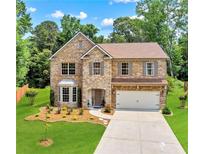 Charming two-story brick home with a well-manicured lawn and attached two-car garage at 3547 Edenridge Ct, Buford, GA 30519