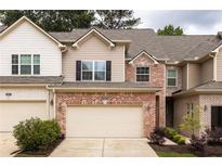 Charming townhome featuring a two-car garage and a mix of brick and siding at 1603 Glen Ivy, Marietta, GA 30062
