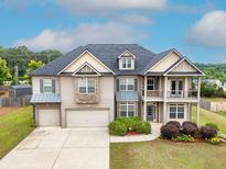 Two-story home featuring a two-car garage, second story balcony, and well-manicured landscaping at 3631 Guinevere Trace Trce, Douglasville, GA 30135