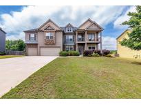 Charming two-story home with a well-manicured lawn and three car garage on a sunny day at 3631 Guinevere Trace Trce, Douglasville, GA 30135