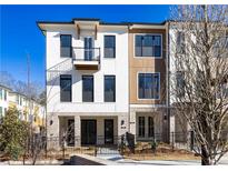 Beautiful three-story townhome with a brick and stucco facade and a small balcony and iron fencing at 350 Olmstead Way # 29, Alpharetta, GA 30022