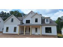Charming two-story home featuring a welcoming front porch with sturdy columns and a classic white facade at 4625 Greyson Manor Dr, Cumming, GA 30041