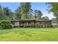 Charming single-story home featuring a large front yard and cozy porch with inviting decor at 267 Firecreek Rdg, Lawrenceville, GA 30046