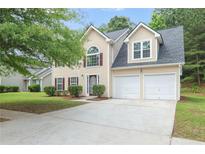 Charming two-story home featuring a two-car garage, manicured lawn, and inviting curb appeal at 5380 Bridle Point Pkwy, Snellville, GA 30039