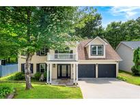 Charming two-story home boasts a welcoming front porch, two-car garage, and lush landscaping, perfect for curb appeal at 1086 Erie Cir, Stone Mountain, GA 30087