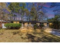 Charming single story home with a well-maintained lawn, shrubbery and a gray brick facade at 2754 Drew Valley Ne Rd, Atlanta, GA 30319