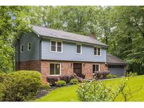 Charming two-story home with blue siding, brick facade, and a well-manicured lawn surrounded by lush trees at 2892 Guinevere Ne Dr, Atlanta, GA 30345