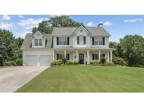 Charming two-story home boasts a manicured lawn and inviting columned front porch at 105 Pine Valley Ct, Hiram, GA 30141