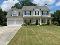 Charming two-story home with a manicured lawn, two-car garage, and inviting front porch at 105 Pine Valley Ct, Hiram, GA 30141
