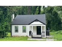 Charming house features a gray roof, white siding, black trim, and a cozy front porch at 15 Harlan Rd, Atlanta, GA 30311