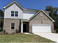 Two-story home with brick facade, attached garage, and well-maintained lawn at 2319 Argento Cir, Dacula, GA 30019