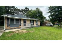 Charming single-story home featuring a brick facade, gray siding, and a well-maintained front lawn at 38 Royce Dr, Jonesboro, GA 30238