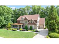Charming brick two-story home with a covered front porch and well-manicured landscaping at 103 Millstone Way, Canton, GA 30115