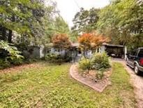 Cozy single-story home featuring a covered carport and a partially wooded front yard at 3617 Bob White Ln, Loganville, GA 30052