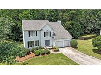 Charming two-story home features a well-manicured lawn, two-car garage, and lush landscaping at 405 Rosedown Way, Lawrenceville, GA 30043
