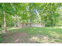 Charming single-story stone home nestled among mature trees and a grassy lawn at 109 Amberidge Nw Dr, Cartersville, GA 30121
