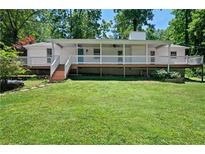 Charming single-story home featuring a full front porch and well-maintained lawn surrounded by mature trees at 5971 Dogwood Se Dr, Acworth, GA 30102
