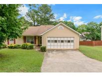 Charming single-story home featuring a well-manicured lawn and attached two-car garage at 9550 Canvasback Ct, Jonesboro, GA 30238