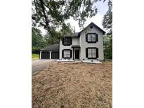 Charming two-story home with an attached two-car garage and a beautifully landscaped front yard at 2720 Thornbury Way, Atlanta, GA 30349