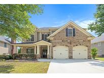 Charming two-story brick home with a well-manicured lawn and a two-car garage at 585 Lawton Bridge Sw Rd, Smyrna, GA 30082