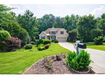 Charming home featuring lush lawn, mature trees, and a neatly manicured garden enhancing curb appeal at 6455 Ivey Meadow Ln, Cumming, GA 30040