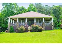 Charming home with a large, inviting front porch, stone accents, and a well-maintained lawn at 6919 Mount Zion Rd, Waco, GA 30182