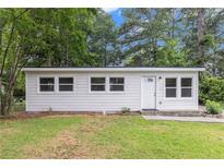 Charming single-story home with a white exterior, complemented by well-maintained landscaping and mature trees at 340 Bell Se St, Marietta, GA 30060