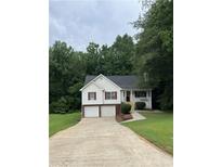 Charming two-story home with a two-car garage and well-manicured lawn, surrounded by lush trees at 645 Robin Rd, Covington, GA 30016