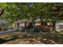 Charming brick home with a landscaped front yard and covered parking at 863 Needle Rock Dr, Stonecrest, GA 30083