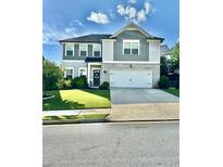 Charming two-story home with a well-manicured lawn, attached two-car garage, and inviting front entrance at 306 Coppergate Ct, Holly Springs, GA 30115