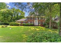 Charming two-story brick home with a manicured lawn and mature trees at 3878 Brookside Pkwy, Decatur, GA 30034