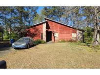 Charming single-story home with red siding, stone accents, and a well-maintained front yard at 6255 Mozart Dr, Riverdale, GA 30296