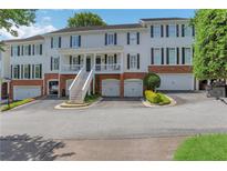 Charming townhome with brick accents, multiple garage spaces, and a welcoming front porch at 620 Neel Reid Dr, Roswell, GA 30075