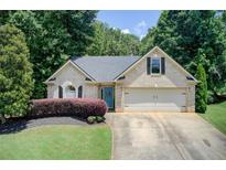 Charming one story brick home with a manicured lawn, attached garage and inviting curb appeal at 130 Stewart Hollow Ln, Covington, GA 30016