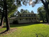 Charming two-story house featuring a welcoming front porch and surrounded by lush greenery at 2055 Pinella Dr, Grayson, GA 30017
