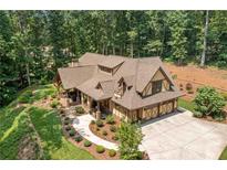 Stunning aerial view of a home with a mature landscaped yard and a three-car garage in a private wooded setting at 2149 Batesville Rd, Canton, GA 30115