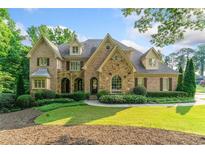Beautiful brick home with manicured landscaping and a charming front yard on a sunny day at 4304 Berkford Ne Cir, Brookhaven, GA 30319