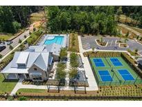 An aerial view of the neighborhood clubhouse with a pool, tennis courts, parking lot, and landscaping at 5330 Keepsake Court, Cumming, GA 30040