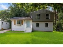 Charming home featuring a well-manicured lawn, updated two-tone paint, and a inviting front entrance at 6192 Holiday Blvd, Forest Park, GA 30297