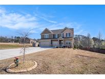 Beautiful two-story home featuring a three-car garage and manicured front yard on a sunny day at 157 Donovan Ave, Locust Grove, GA 30248